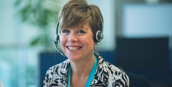 Customer service employee smiling with a headset on