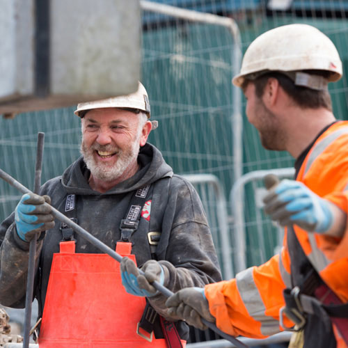 Two male Wessex Water construction workers on site smiling and working